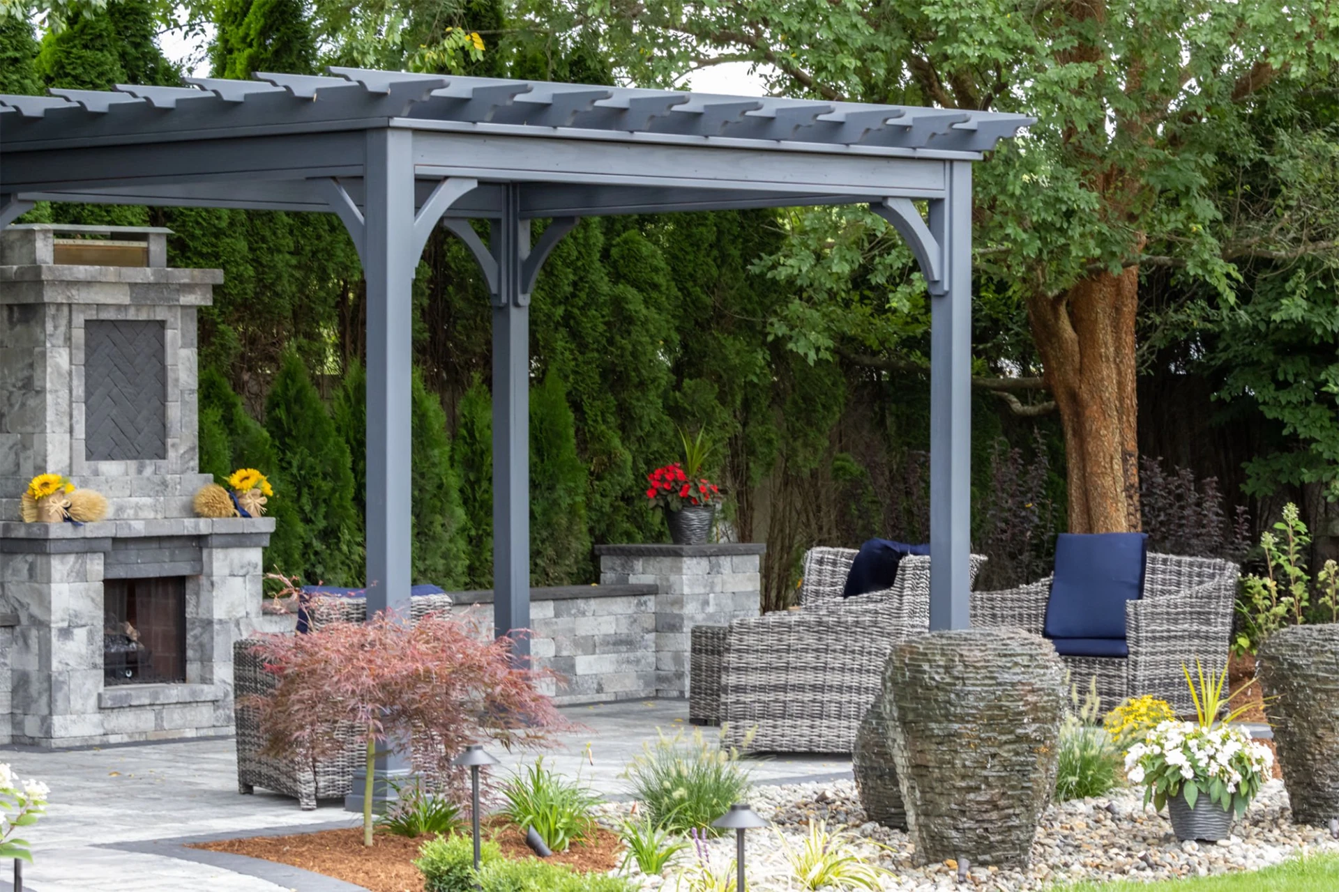 landscape-architecture-featuring-pergola-and-stone-fireplace-with-trees-on-the-background