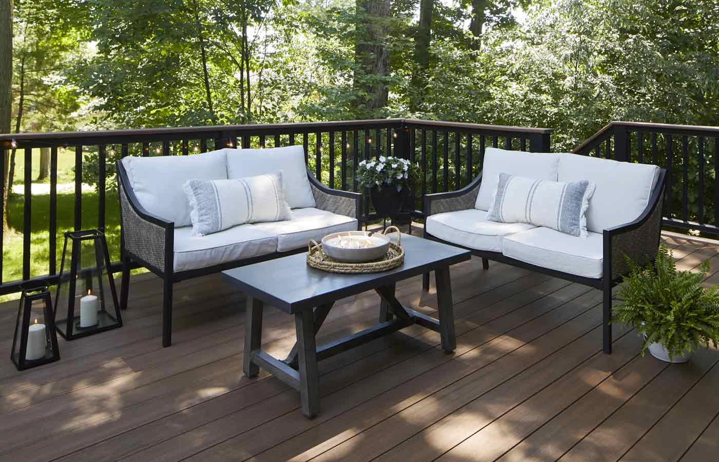 mahogany-wood-decking-with-outdoor-furniture-and-black-railing-featuring-forest-background