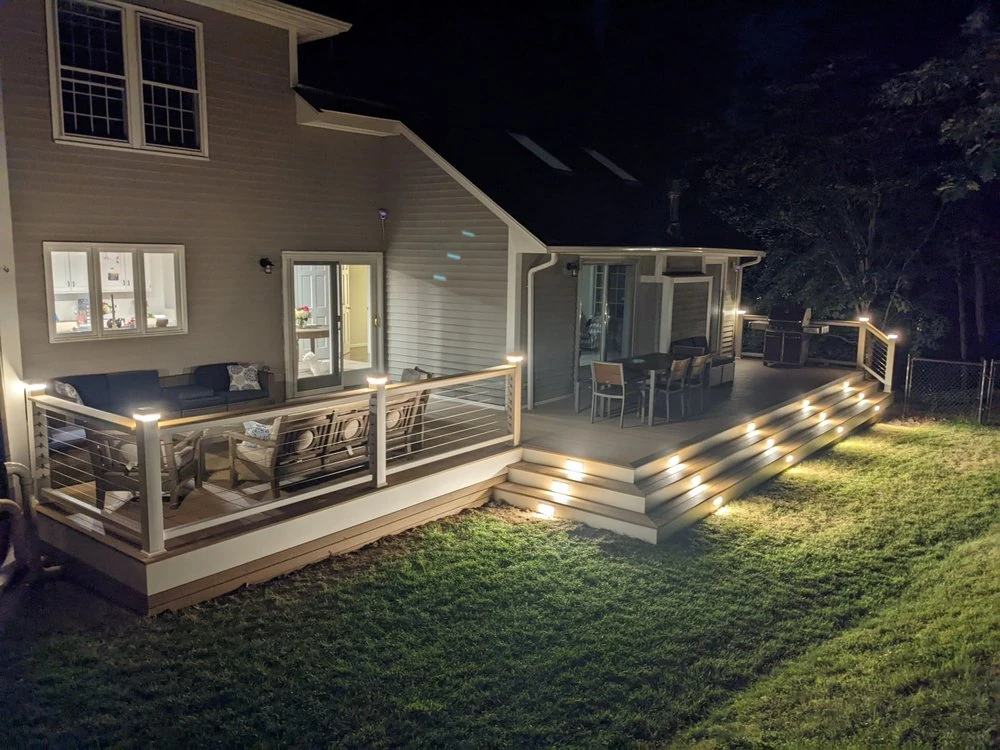 night-time-of-residential-deck-with-lighting-and-wire-railing-featuring-outdoor-living-furniture
